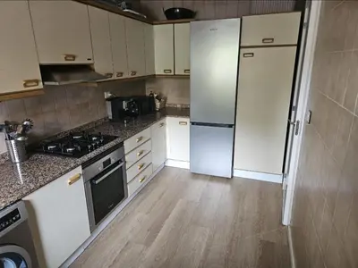 a kitchen with white appliances and wooden floors at La Cañada in Partida de La Cañada
