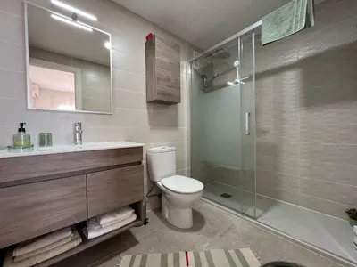 a bathroom with a toilet and a glass shower at Panorama Azul Apartment in El Puig