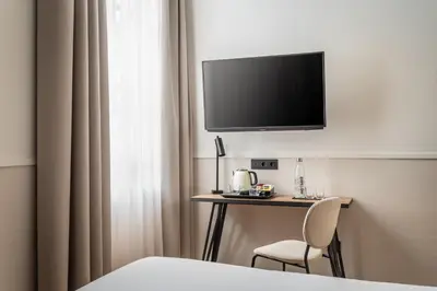 a hotel room with a desk with a television on the wall at BYPILLOW Sinfonía in Valencia