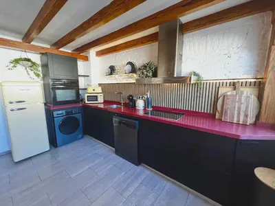 a kitchen with black cabinets and a red counter top at Luxury penthouse center appartement in Valencia
