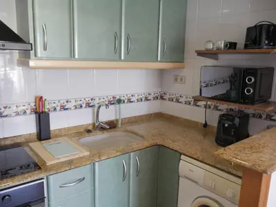 a kitchen with green cabinets and a sink at Malvarrosa, 1-6 in Cullera