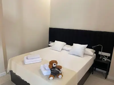 a teddy bear sitting on a bed with towels at Osito Hub - Campoamor in Valencia