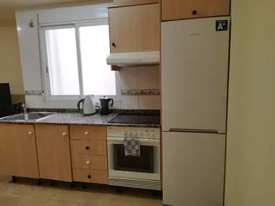 a kitchen with a refrigerator and a stove and a window at Apartamento cerca del puerto deportivo 1 in Burriana