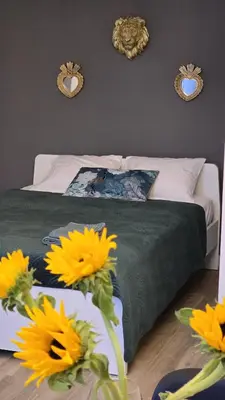 a bedroom with a bed with yellow flowers and mirrors at Inspiracion Valencia in Valencia
