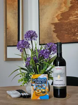 a bottle of wine next to a vase of purple flowers at Inspiracion Valencia in Valencia
