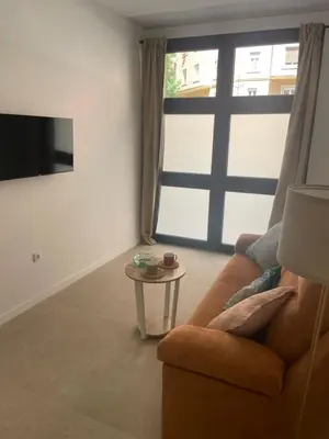 a living room with a couch and a large window at Galdós Flats by Vivo GC in Valencia