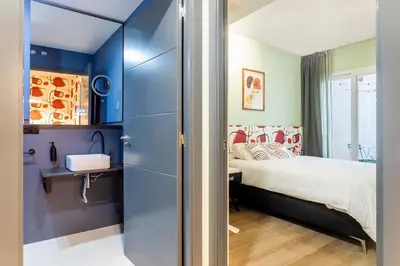 a small bedroom with a bed and a sink at Apartamento B Cube by Mimood Aparthotels in Valencia
