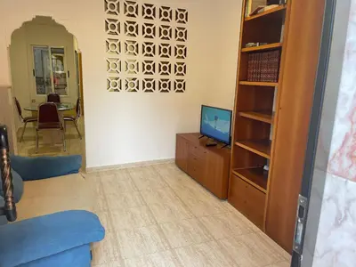 a living room with a blue couch and a television at Casa JUANES in Cullera