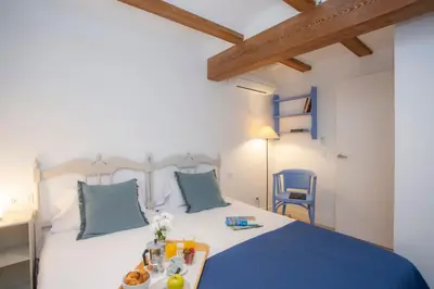 a bedroom with a bed and a blue chair at SingularStays Casa del Grao in Valencia