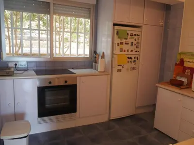 a kitchen with white cabinets and a refrigerator at HAWAI, Esc-3, 3-16 in Faro de Cullera