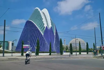a person riding a bike in front of a building at Romantic Apartment N.4 Oceanografico Virkin Suites in Valencia