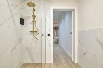 a glass shower door in a bathroom with white walls at Romantic Apartment N6 Oceanografico Virkin Suites in Valencia