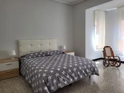 a bedroom with a bed and a chair and a window at Bella Morvedre in Sagunto