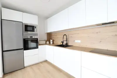 a white kitchen with white cabinets and a sink at Tradición y modernidad Casa de pueblo junto al mar in Puerto de Sagunto