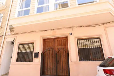 a house with a wooden door and two gates at Tradición y modernidad Casa de pueblo junto al mar in Puerto de Sagunto