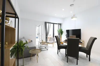 a living room with a table and chairs and a dining room at Deslumbrante y familiar casa cerca de la playa in Puerto de Sagunto