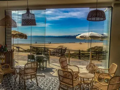 a restaurant with a table and chairs and the ocean at Apartamento Premium frente al mar, en primera linea de playa in Cullera