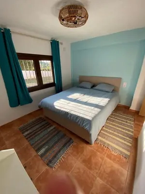 a bedroom with a bed with blue walls and blue curtains at Rey Elzinga in Godelleta