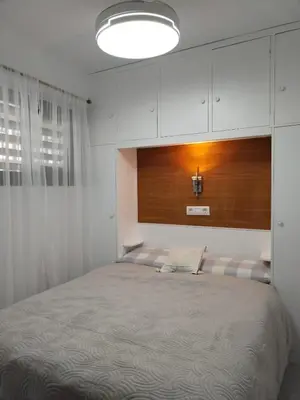 a bedroom with a large bed with a wooden headboard at Ático Playa Cullera in Cullera