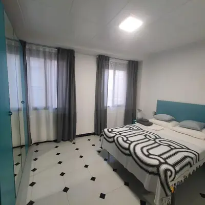 a bedroom with two beds and a black and white floor at Casa Central in Cullera