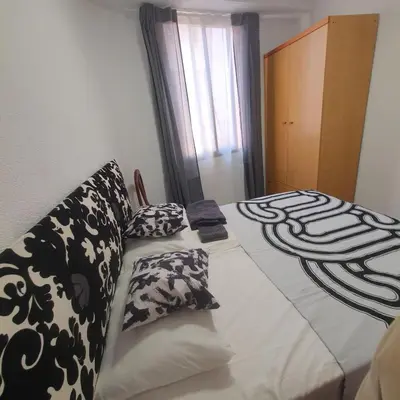 a bedroom with a bed with black and white pillows at Casa Central in Cullera