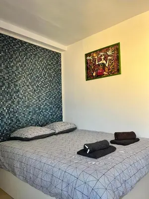 a bed with two pillows on it in a room at Cozy Flat with City & Beach in Puerto de Sagunto