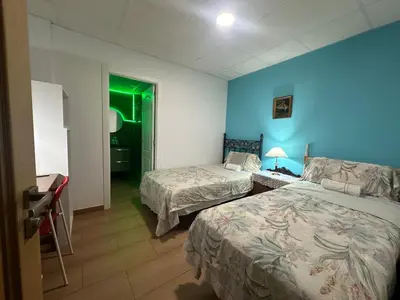 a hotel room with two beds and a green light at Mirador 5 del Mercado Central - habitacion con baño privado en el centro de la Ciudad Vella in Valencia