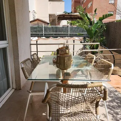 a glass table on a balcony with wicker chairs at MD Malva Valterna in Paterna