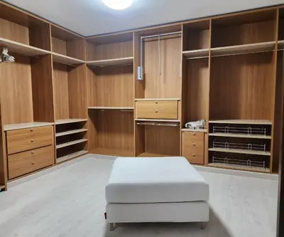 a large closet with wooden cabinets and a white ottoman at MD Malva Valterna in Paterna