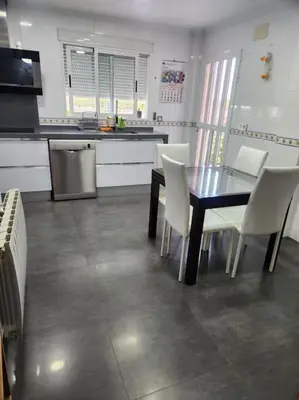 a kitchen with a dining table and white chairs at Casa Villa Molins in Valencia