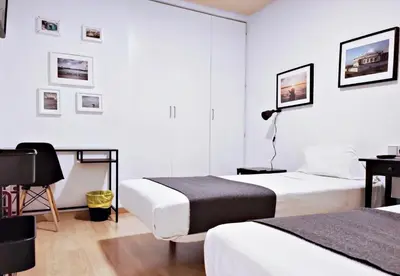 a hotel room with two beds and a desk at Apartamento junto Mercado Central Valencia in Valencia