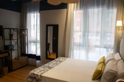 a bedroom with a bed and a large window at Maison Primado B&B in Valencia
