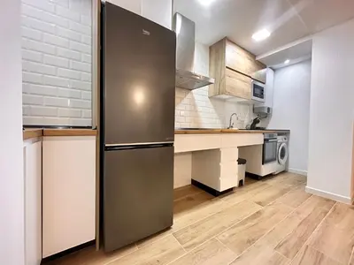 a kitchen with a stainless steel refrigerator in a room at Valencia & Suites Ayora in Valencia