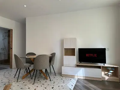a living room with a table and chairs and a television at Del Mar 1A - New Beach First floor apartment in Puerto de Sagunto
