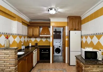 a kitchen with a white refrigerator and a microwave at Apartamento en la Sierra Espadan in Artana