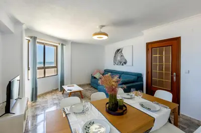 a living room with a table and a blue couch at ViDa MaLu - Housevanlive in Sueca