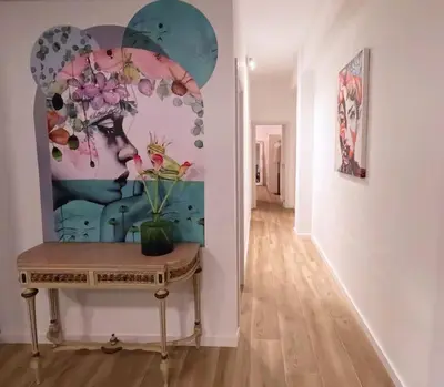 a hallway with a table with a painting on the wall at Amplio y colorido piso in Valencia
