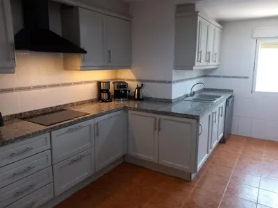a kitchen with white cabinets and granite counter tops at The Villarosa in Turís
