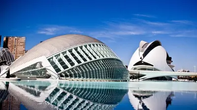 a view of a building with its reflection in the water at Apartamento Plaza Palmeras in Burjasot