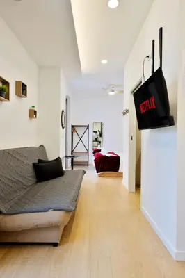 a living room with a bed and a tv on a wall at Apartamento RD A in Valencia