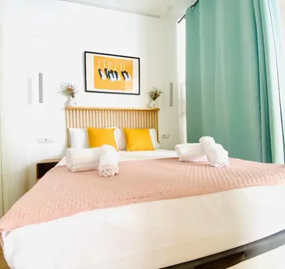 a bedroom with a large bed with orange and white pillows at BAJO B - Design & Comfort in Ruzafa SOHO in Valencia