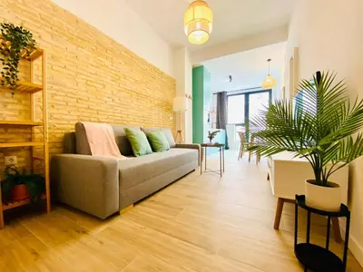 a living room with a couch and a brick wall at BAJO C - Design & Comfort in Ruzafa SOHO in Valencia