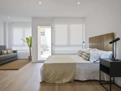 a bedroom with a large bed and a living room at Estudio Temporal a 2' de la playa de Sagunto A2 in Puerto de Sagunto
