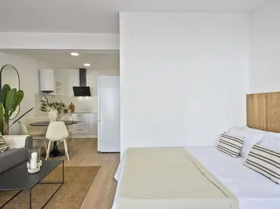 a living room with a large bed and a kitchen at Moderno estudio a 2 minutos de la Playa Sagunto A3 in Puerto de Sagunto