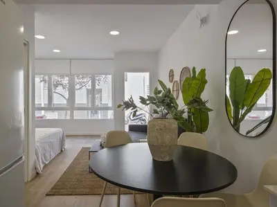 a living room with a table and a vase with plants at Moderno estudio a 2 minutos de la Playa Sagunto A3 in Puerto de Sagunto