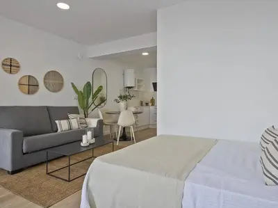 a living room with a bed and a couch at Moderno estudio a 2 minutos de la Playa Sagunto A3 in Puerto de Sagunto