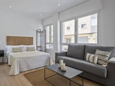 a living room with a bed and a couch at Refugio Costero a 2 minutos de Playa Sagunto A4 in Puerto de Sagunto