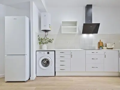 a white kitchen with a refrigerator and a washing machine at Escondite a 2 minutos de playa de Sagunto A5 in Puerto de Sagunto
