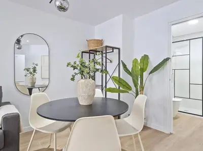 a dining room with a black table and white chairs at Escondite a 2 minutos de playa de Sagunto A5 in Puerto de Sagunto