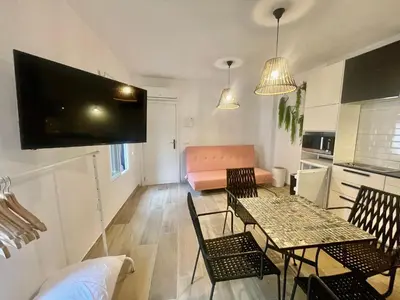 a living room with a table and chairs and a couch at ESTUDIO CON JACCUZI Y SAUNA montaña y playa in Tavernes de Valldigna